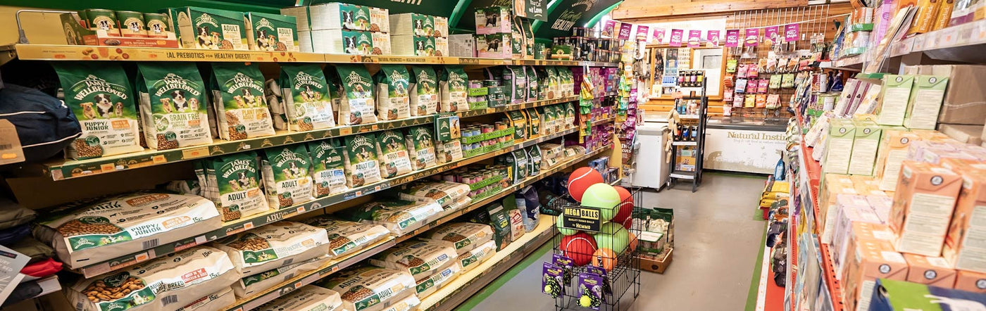 Supermarket aisle with shelves stocked with products and a checkout area.