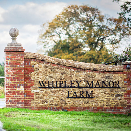 Entrance to Whipple Manor Farm with a stone and brick wall sign.