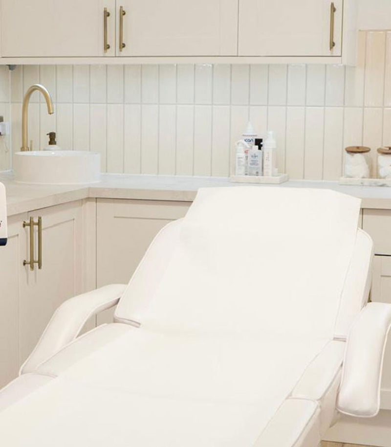 White recliner chair in a spa or salon setting with neutral decor.